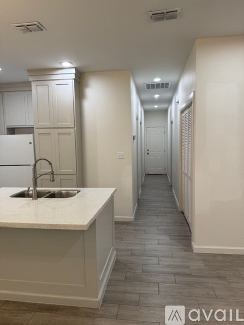 A kitchen with a sink and a long hallway.