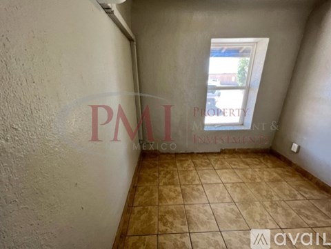 A room with a window and tiled floor.