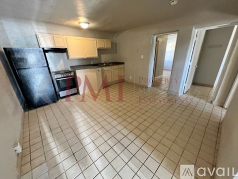 A kitchen with black appliances and white cabinets is available for rent.
