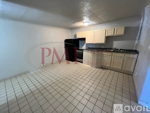 A kitchen with white tiled floors and white cabinets.