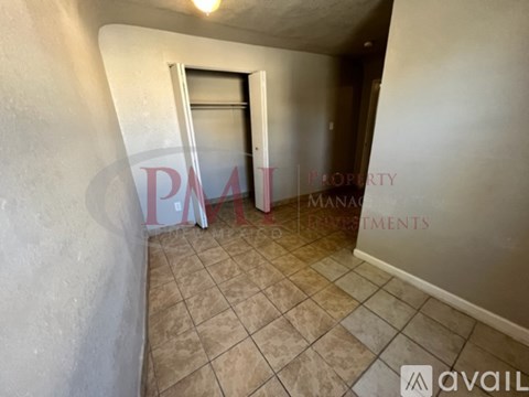 A hallway with tiled flooring and a doorway leading to another room.