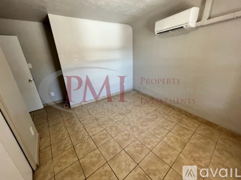 A room with tiled flooring and a wall with the text "PMI Property Investments" written on it.