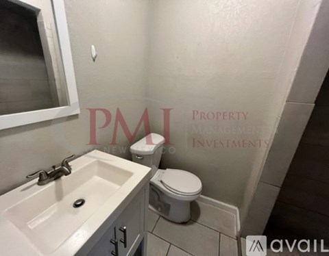 A white sink with a silver faucet and a toilet in a bathroom.