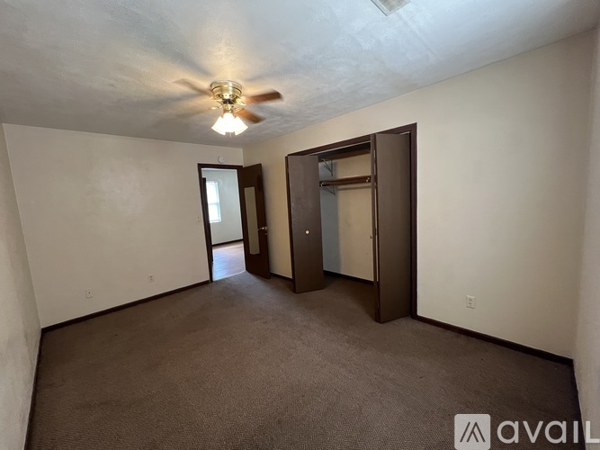 A room with a ceiling fan and two doors.