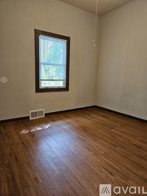 A room with a window and wooden floor.