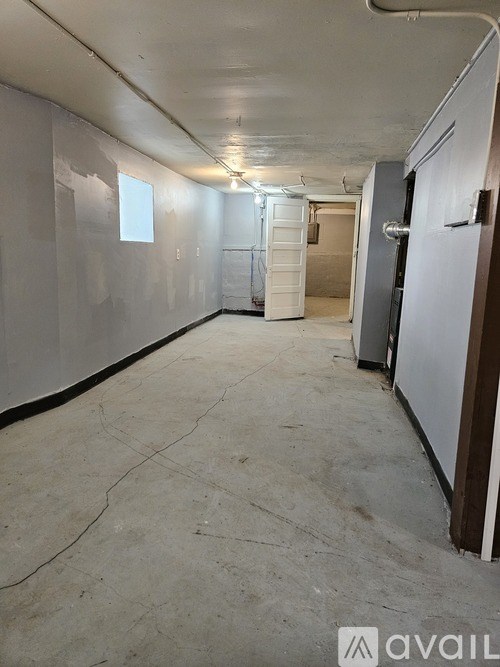 A long hallway with a white door at the end.