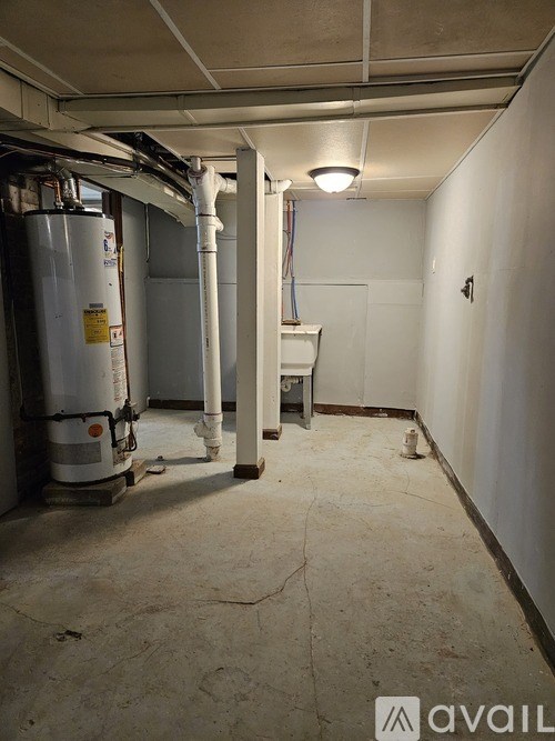 A room with a white wall and a pipe running along it.