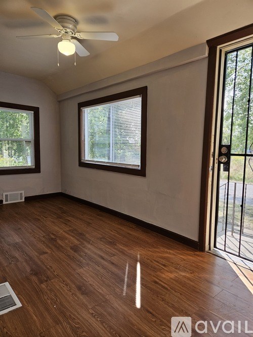 A room with wooden floors and a ceiling fan.