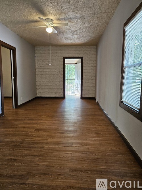 A room with wooden floors and a ceiling fan.
