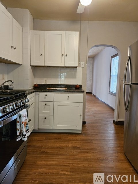 A kitchen with white cabinets and a black stove top.
