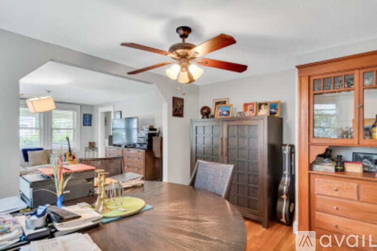 A room with a table and a fan.