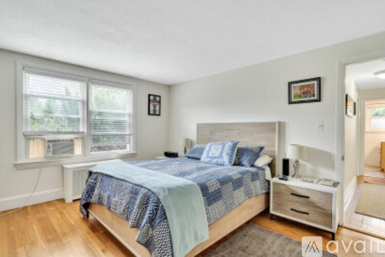 A bedroom with a bed, nightstand, and window.