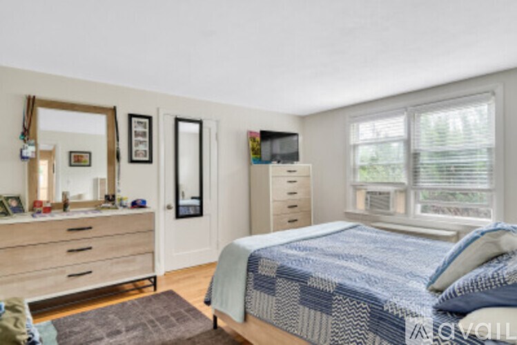 A bedroom with a bed, dresser, and mirror.
