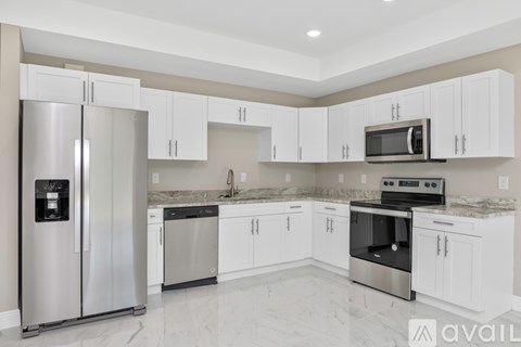 A kitchen with white cabinets and stainless steel appliances.