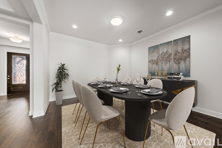 A dining room with a round table and chairs.