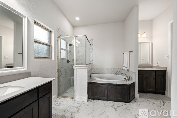 A modern bathroom with a marble floor and a walk-in shower.