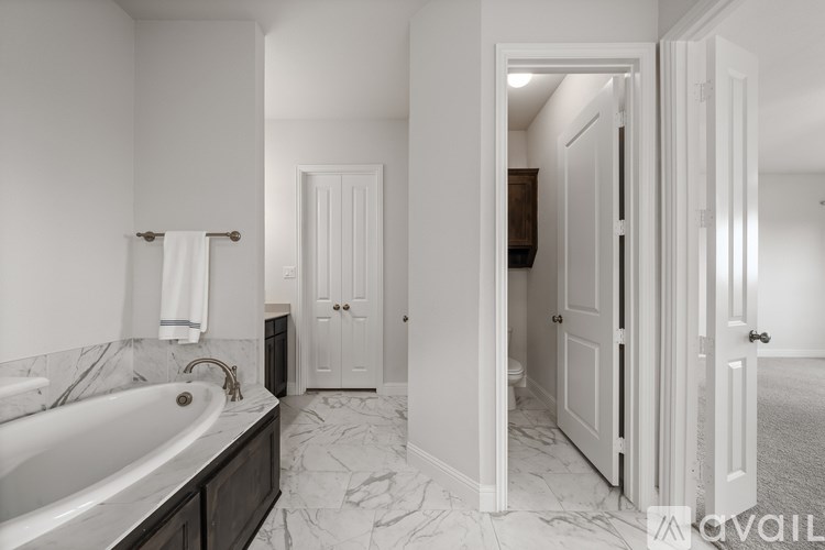 A bathroom with a marble floor and white walls.
