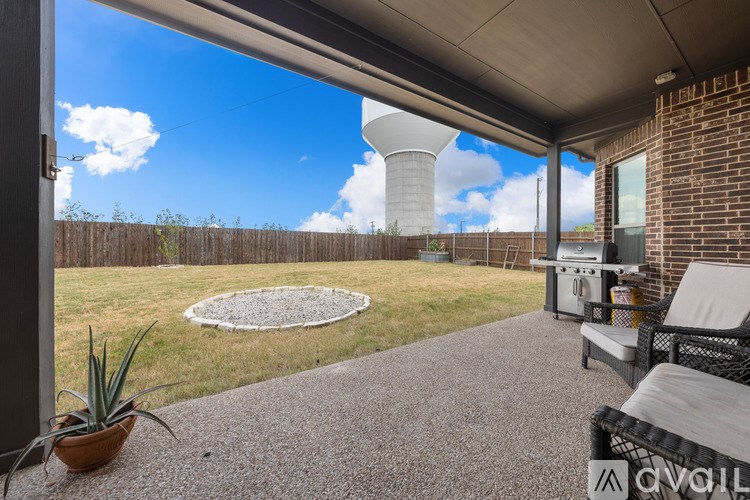 A patio with a table and chairs overlooking a field.