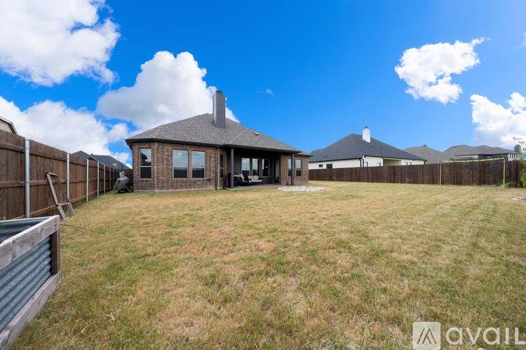 A backyard with a house and a fence.