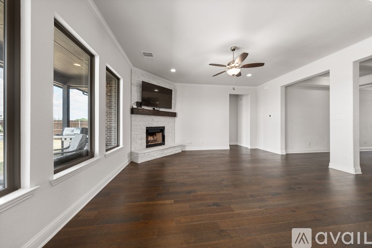 A spacious room with a fireplace and a ceiling fan.