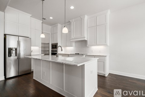 A modern kitchen with white cabinets and a center island.
