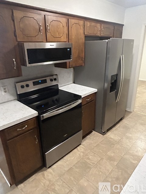 A kitchen with a stove top oven, microwave, and refrigerator.