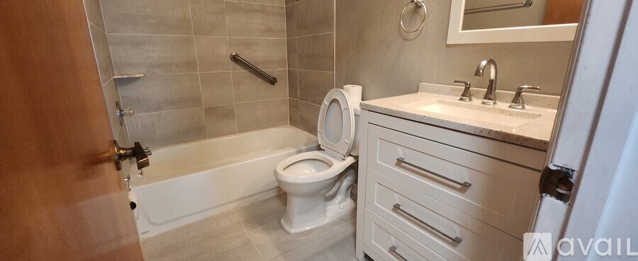 A bathroom with a toilet, sink, and bathtub.