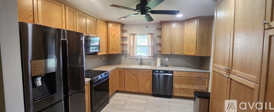 A kitchen with wooden cabinets and black appliances.
