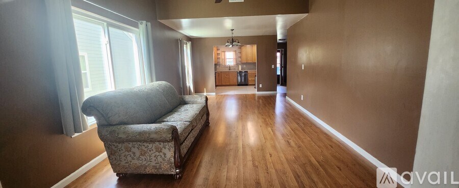 A living room with a couch and a wooden floor.