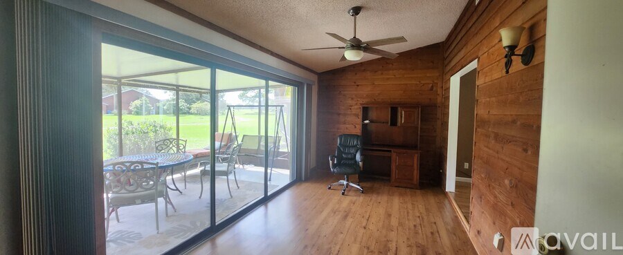A room with wooden walls and a ceiling fan.