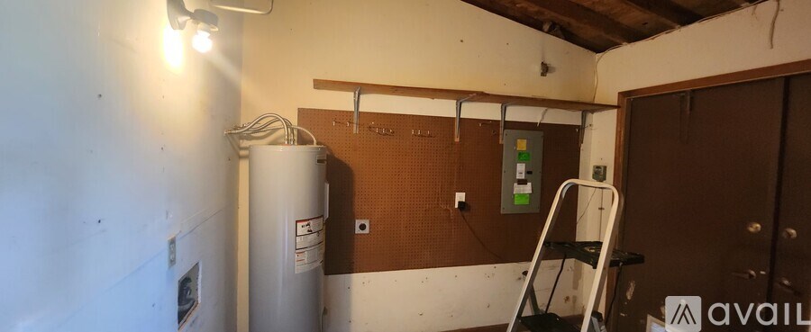 A room with a water heater and a sign on the wall.