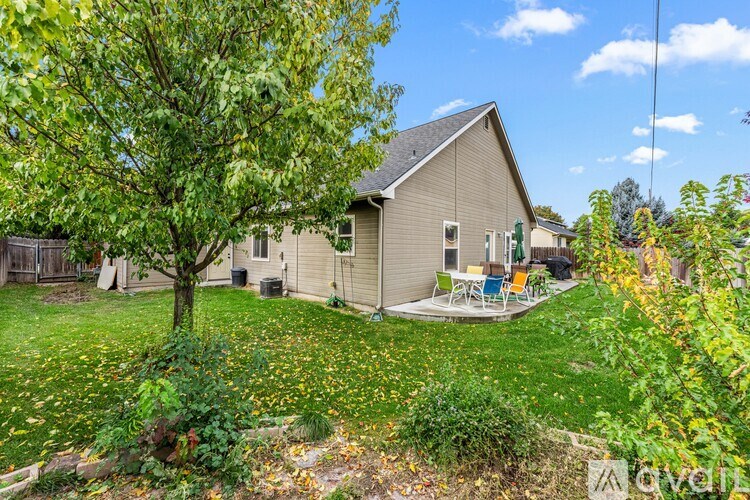 A house with a lawn and a tree in front of it.