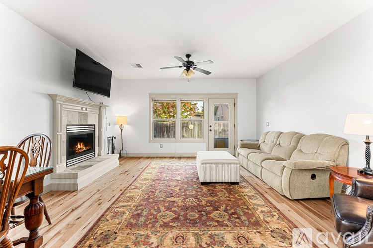 A living room with a fireplace, a couch, a chair, and a rug.
