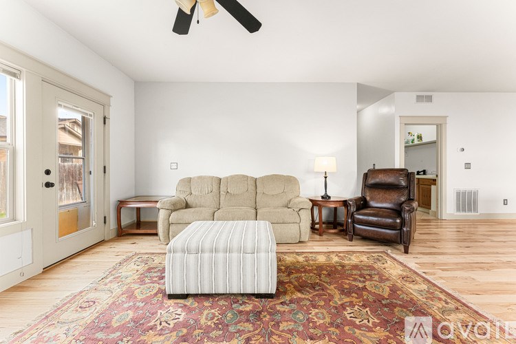 A living room with a rug and two chairs.