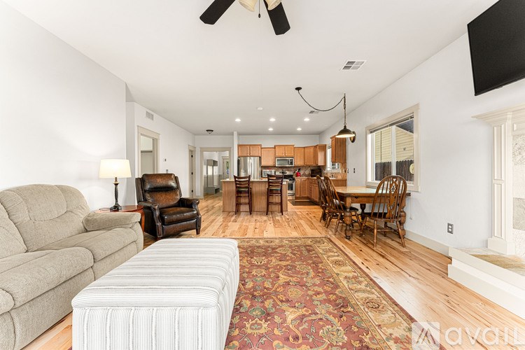 A living room with a couch, chairs, and a rug.