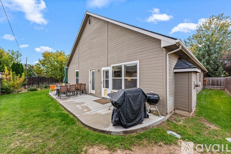 A house with a covered patio and a BBQ grill.