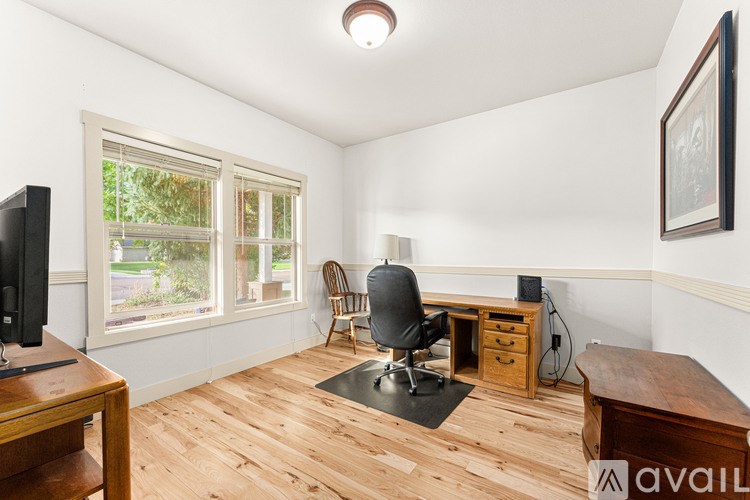 A room with a desk, chair, and a window.