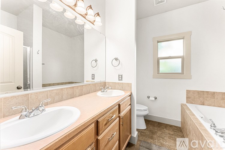 A bathroom with a sink, toilet, and tub.