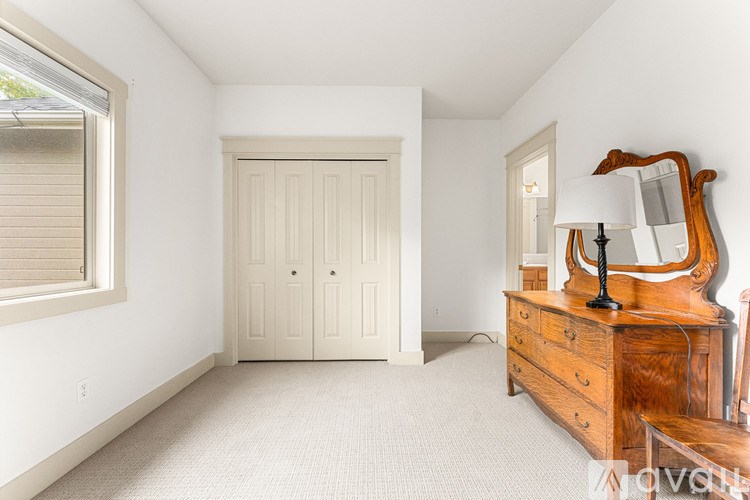 A bedroom with a wooden dresser and a white door.