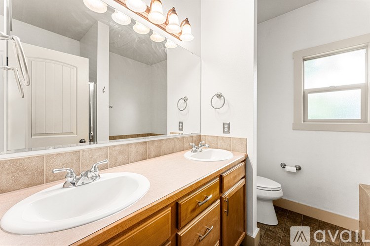 A bathroom with a sink, mirror, and toilet.