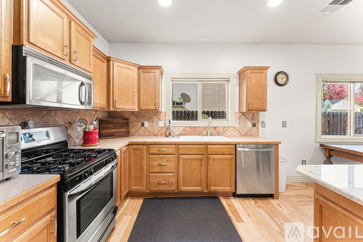 A kitchen with wooden cabinets and a black stove top.