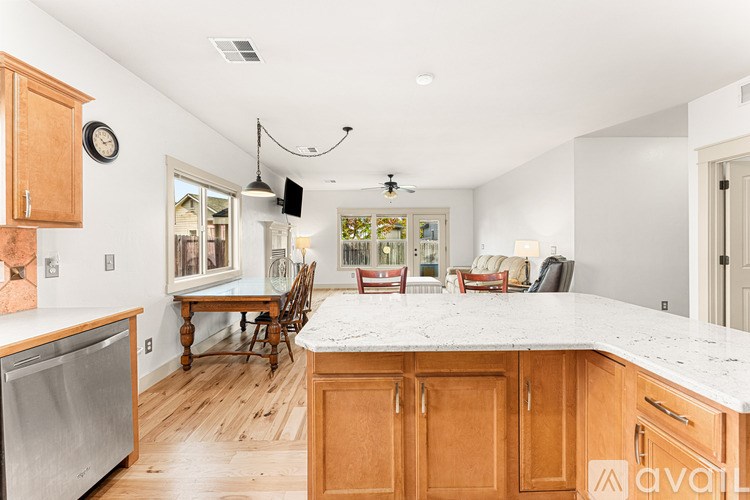 A kitchen with wooden cabinets and a marble countertop.