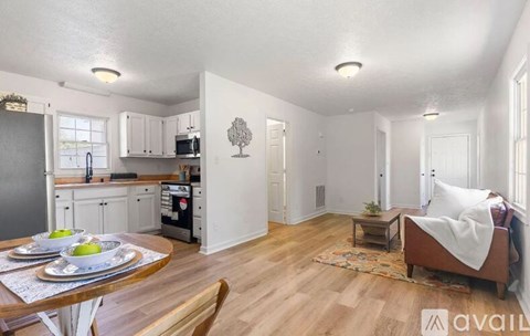 A kitchen with a dining table and a couch in the living room.