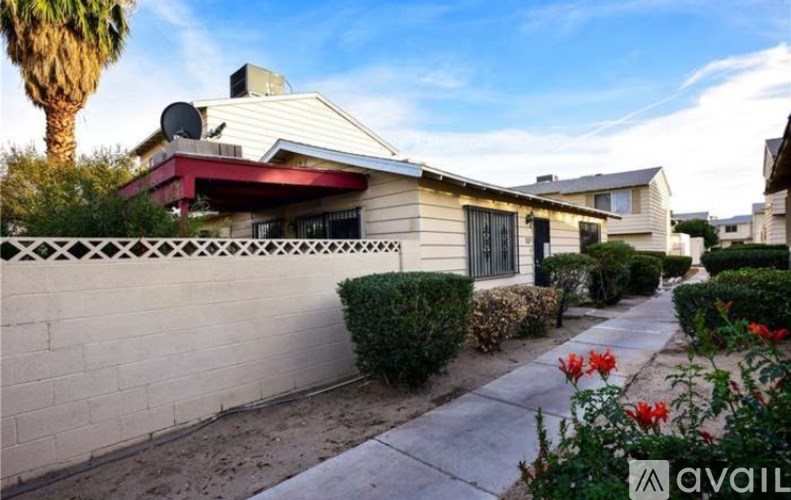 A house with a red roof and a white fence is for sale.