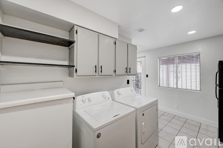 A small, white laundry room with a washer and dryer.