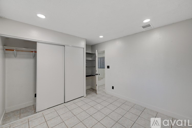 A white room with a white floor and white walls with a white closet with a white door.