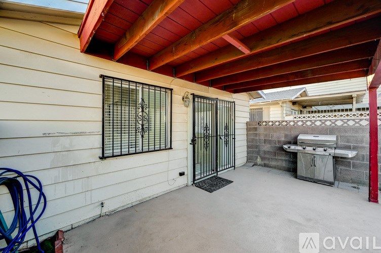 A patio area with a grill and a gate.
