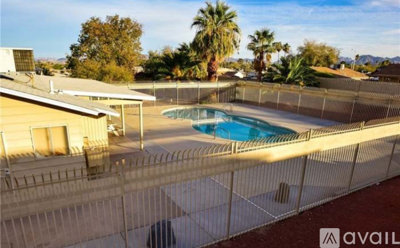A pool surrounded by a fence in a sunny backyard.