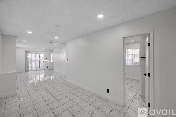 A spacious room with white walls and a tiled floor.