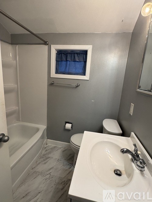 A bathroom with a white sink, toilet, and bathtub.